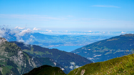 ベルナーオーバーラント地方の標高高い山肌から俯瞰した、湖と山々に囲まれたスイスの美しい自然景観