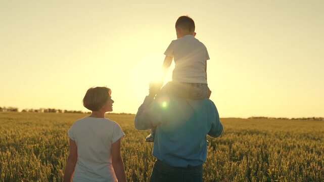 teamwork. child sits on his father's shoulders rides. happy family in the wheat field. family summer walk at sunset. mother father little boy child son. childhood dream happy family vacation holidays