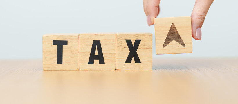 hand change wooden block with TAX text to UP and Down arrow icon. decrease and Increase, Taxpayer, Taxable Income, Tax Filing, Deduction, Withholding Tax, WHT, VAT, Computation and Exemption concept