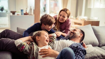 Obraz premium Happy young family enjoying playful moment on cozy couch in warm living room,parents bonding with children,laughter and joy at home