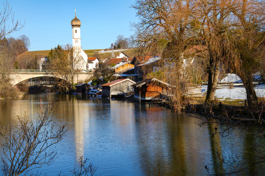 Winter idyll in Gmund in Bavaria at the outlet of the Mangfall River from Lake Tegernsee. In the background is the Mangfallsteg, a striking wooden bridge with picturesque views of the lake