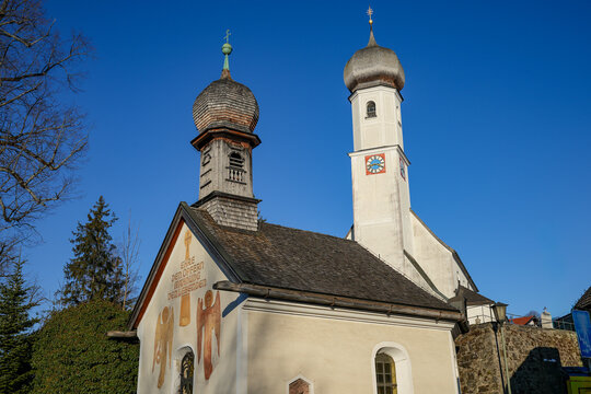 The Maria Hilf Chapel in Gmund at Lake Tegernsee in Bavaria and the Catholic parish church of St. &Auml;gidius with its striking onion dome in the background against a blue sky