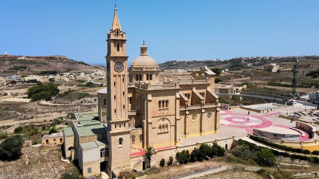 Side aerial drone view of Ta Pinu Basilica and circular square in Gharb, Gozo Malta.