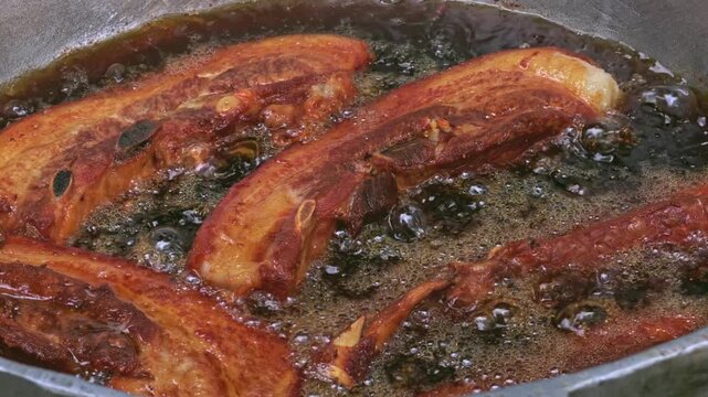 Traditional chicharron de cerdo deep frying in a pot in Santiago, Dominican Republic