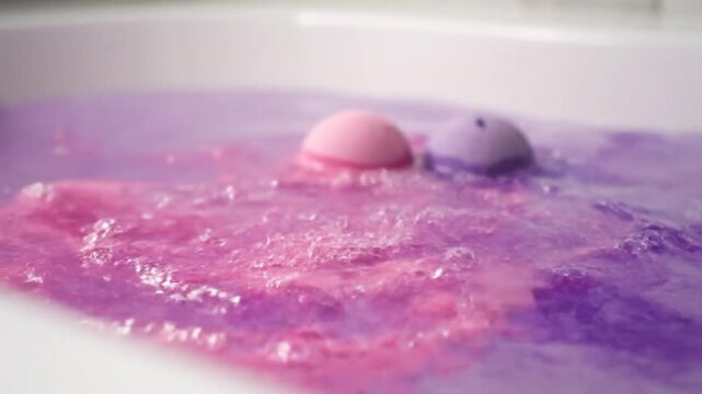 Colorful bath bombs fizzing and dissolving in a bathtub creating a relaxing and vibrant experience