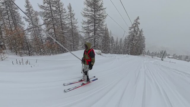 Skier On Skis Using Poma Lift On A Snowy Mountain Slope. - wide shot
