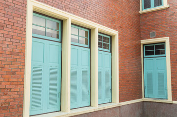Vintage red brick wall with classic light blue wooden windows
