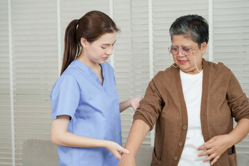 Asian female physiotherapist examines arm movement of senior asian woman while checking shoulder mobility during personalized rehabilitation training in therapy room