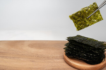 흰 배경에 젓가락으로 잡고 있는 한국 전통 김