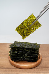 흰 배경에 젓가락으로 잡고 있는 한국 전통 김