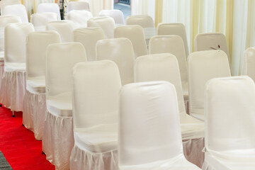 Fototapeta premium The repetition of empty white chair in the room in the morning
