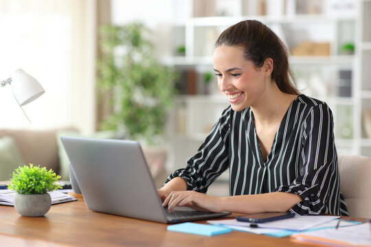 Happy tele worker working online using laptop at home