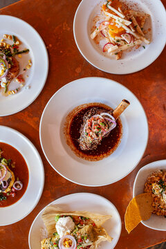 Overhead view of copper table top covered in various entrees