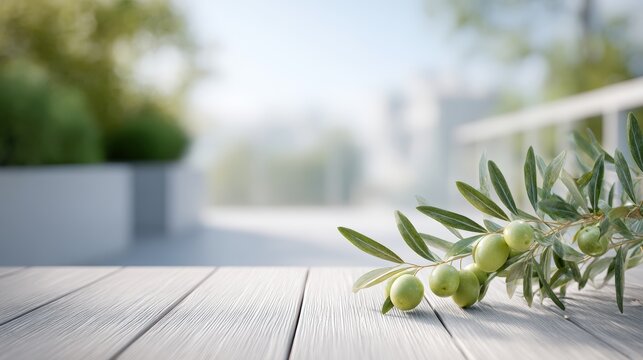 Olive tree branch with green olives resting on a wooden table, surrounded by a blurred outdoor setting featuring greenery and soft natural light in a tranquil environment
