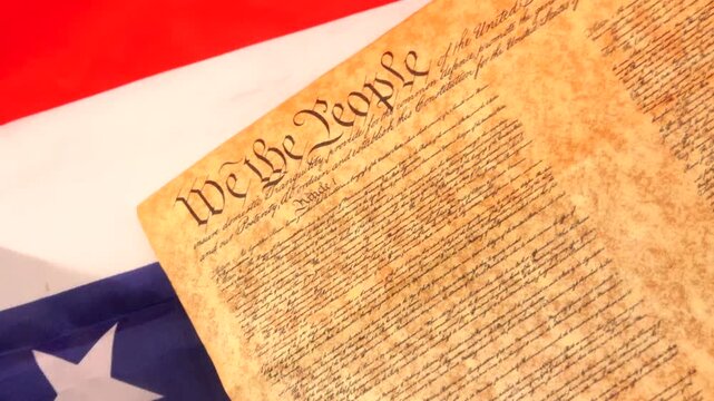 A dramatic image of the U.S. Constitution resting on a burning American flag, symbolizing protest, civil liberties, and the ongoing tension between patriotism and dissent