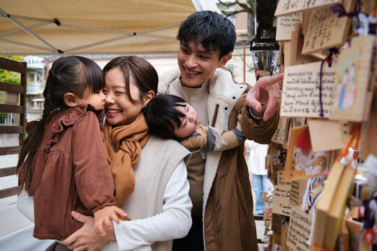Family smiling together at Senso-ji temple with Ema wish plaques in Tokyo