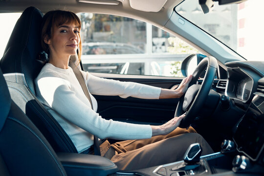 Woman driving in modern car wearing seatbelt
