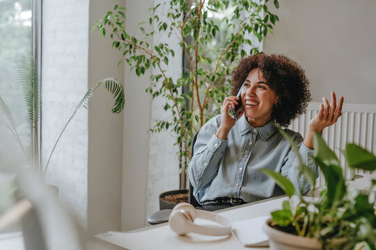 Businesswoman smiling on the phone at a modern indoor office desk