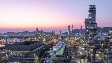 Obraz na płótnie Canvas Aerial view oil and gas petrochemical storage tank with oil and gas refinery plant at twilight, Global business power and energy petrochemical industry, Oil and gas refinery petrochemical industrial.