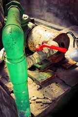 Old Rusty Industrial Valve and Electric Motor with Red Handwheel