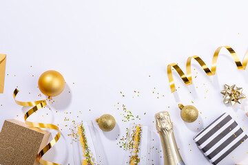 Overhead shot of christmas gifts and decoration by champagne over white background, copy space