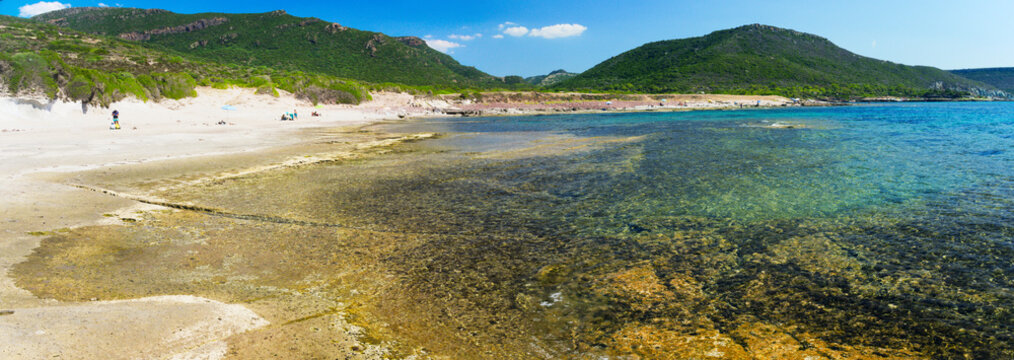 Wide format view of the bay and the beach between the coastal locations of Sa Rocca Lada and Torre Argentina. Sardinia, Italy