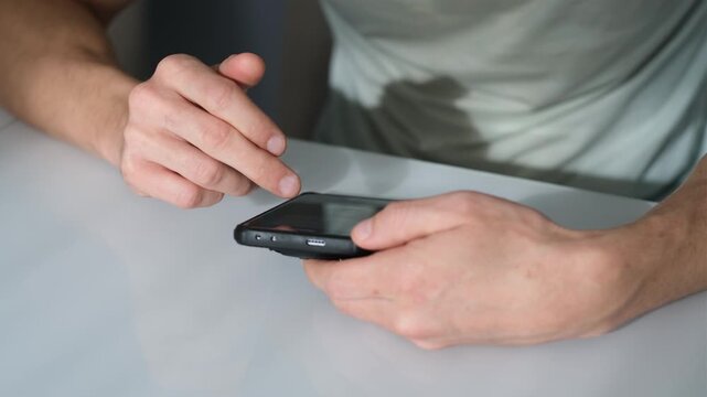 Men's hands tapping on a phone screen
