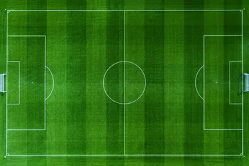Fototapeten Grün High-angle aerial top view of a pristine green soccer field. Professional football pitch with white markings, goal posts, and textured grass stripes. Perfect for sports and recreation designs.  © alones