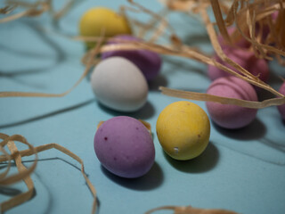 Easter display with chocolate eggs and straw blue background