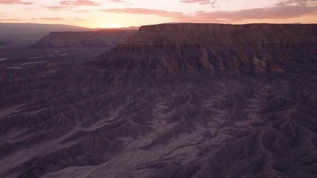 Aerial view of mesas and canyons under a pastel sky, a study in contrasts of light and shadow, texture and tone, Hanksville, Utah, United States.