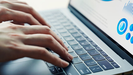 オフィスでノートパソコンを使う女性ビジネスパーソンの手元アップ