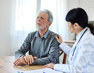 Obraz premium Portrait of a female doctor and senior man patient with a headache at her doctor's office in clinic