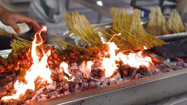 Street Vendor Grilling Meat Satay Over Open Charcoal Flames in Singapore