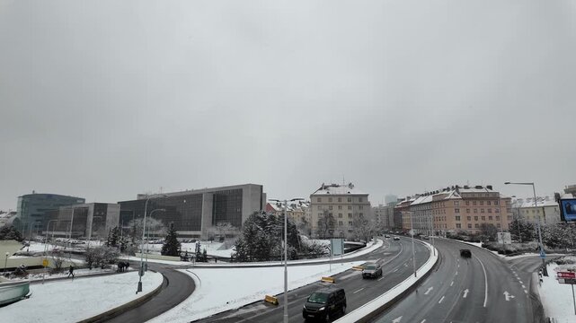 Prague, Czech Republic - January 29, 2026 - Pankrac - Snowy urban highway with cars and buildings under a cloudy winter sky