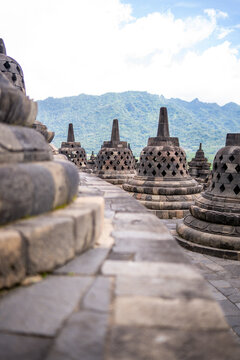 Historische Stupas des Borobudur Tempels vor Bergkulisse auf Java