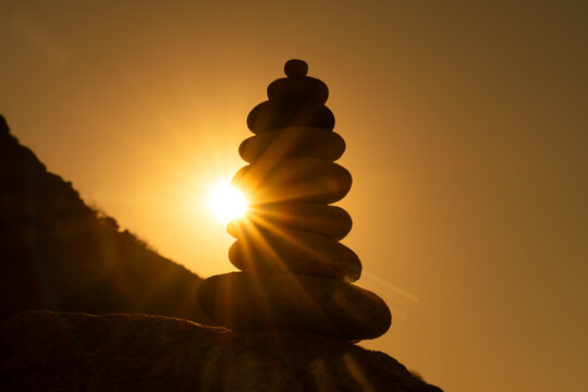 Balance stones sunset silhouette of a stacked cairn against a vibrant golden sky representing spirituality and zen concepts