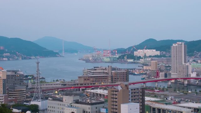 Nagasaki, Japan. Aerial timelapse made from a hill in Nagasaki, Japan, with a view over the entire center, including the bay and the hills. Cloudy and sunny morning in summer, panning video