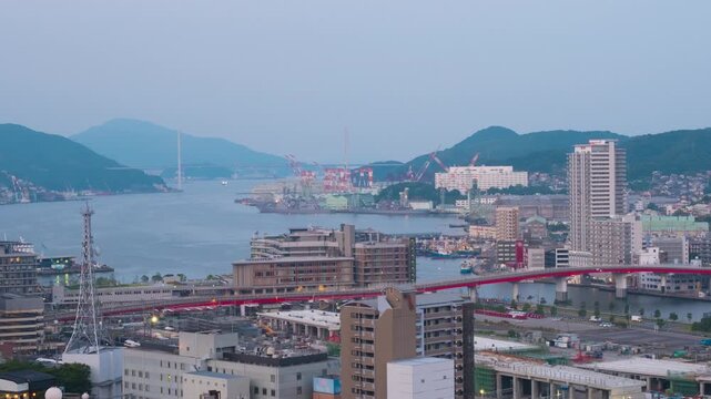 Nagasaki, Japan. Aerial timelapse made from a hill in Nagasaki, Japan, with a view over the entire center, including the bay and the hills. Cloudy and sunny morning in summer