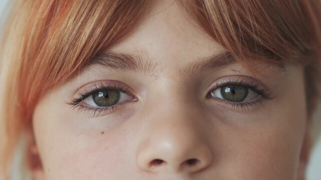 Closeup portrait face of happy caucasian girl elementary school blond ginger redhead hair, smiling, grey eyes. Looking at camera. Positive mood, joyful, cheerful kid child, laugh over white background