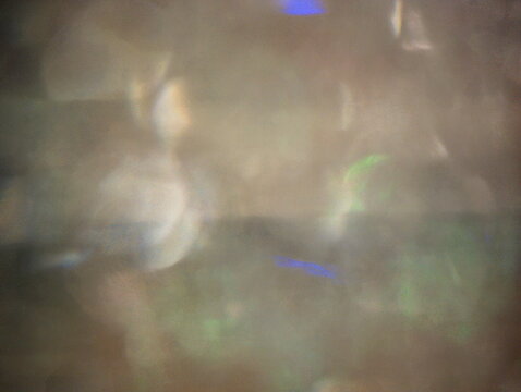 Ripresa astratta con luci diffuse multicolore fuori fuoco, caratterizzata da riflessi morbidi e texture eterea 