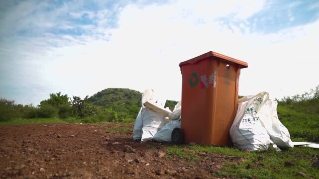 Cinematic shot of collected trash bags and a recycling bin, during an environmental cleanup at Cerro del Piloncillo in Irapuato, highlighting sustainabillity ecology and community acction.