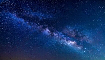Fototapeta premium A breathtaking night sky filled with stars and the Milky Way galaxy viewed from a serene landscape