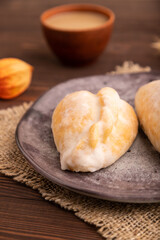 Glazed Pies with Cowberry jam on brown wooden, side view, close up, selective focus