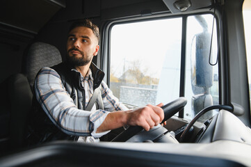 Obraz premium Male truck driver concentrating while steering vehicle