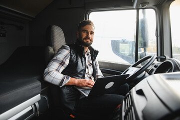 Truck driver networking with laptop inside cab