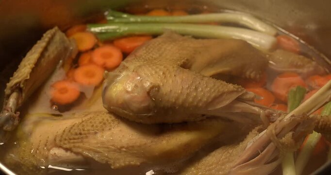 Organic chicken broth is boiling. Homemade chicken broth. Chicken soup.