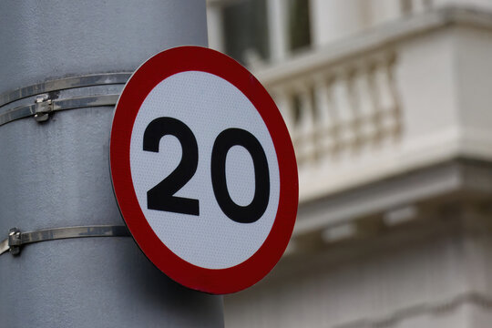 Speed limit sign indicating 20 mph on a street in London, UK.