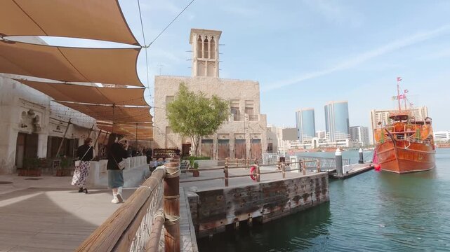 Dubai, UAE - 25th january, 2026: Timelapse zoom in Old Dubai waterfront at Dubai Creek showing traditional wind tower architecture, wooden dhow boats, heritage district and modern skyline contrast
