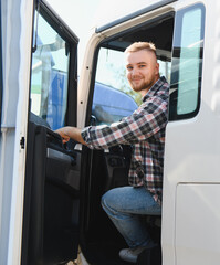 Young truck driver smiling entering cabin of vehicle