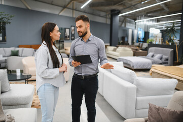 Sales consultant assisting female customer choosing furniture